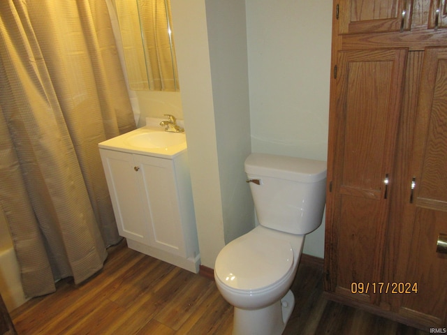 bathroom with vanity, toilet, hardwood / wood-style floors, and curtained shower