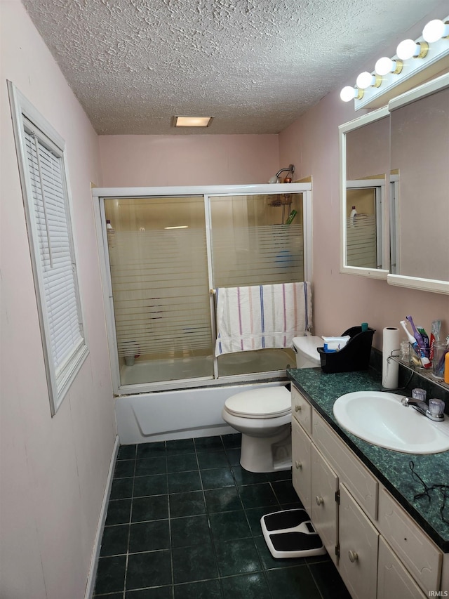 full bathroom featuring shower / bath combination with glass door, vanity, tile patterned flooring, and toilet