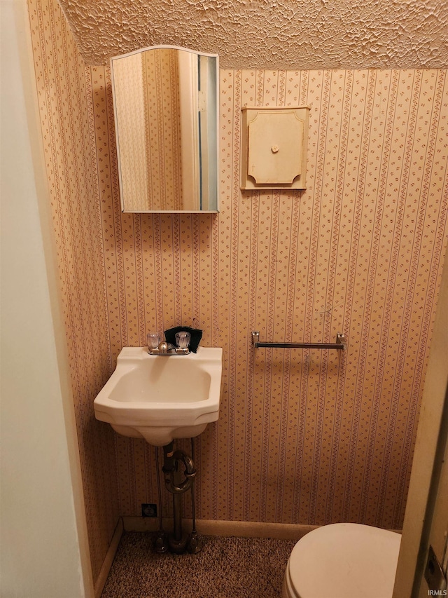 bathroom featuring a textured ceiling and toilet