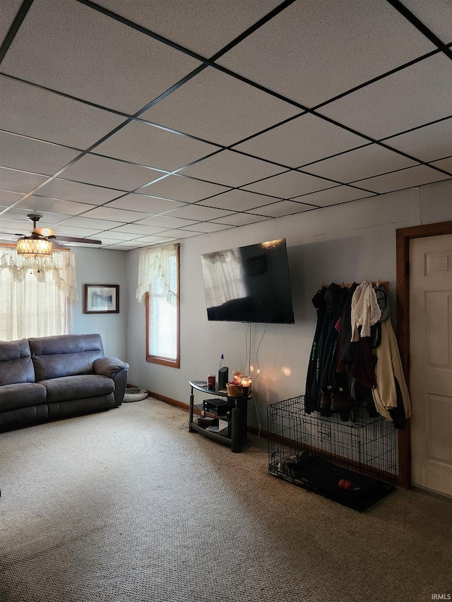 carpeted living room with a drop ceiling and ceiling fan