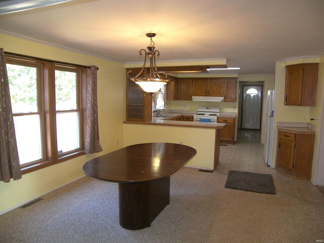 kitchen featuring white appliances, kitchen peninsula, pendant lighting, sink, and light colored carpet