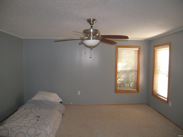 unfurnished bedroom with ceiling fan, a textured ceiling, and carpet flooring