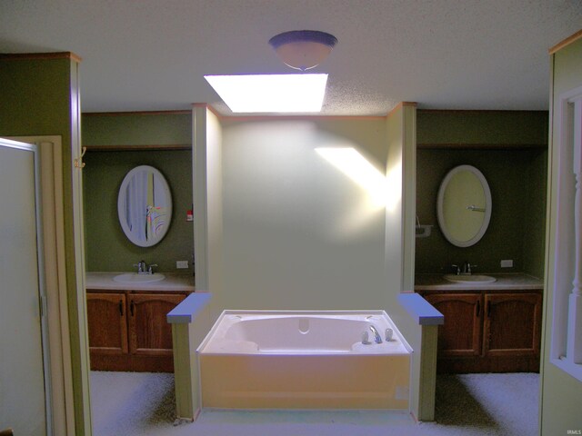 bathroom featuring a skylight, vanity, and a bathtub