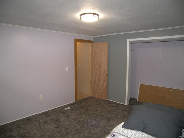 unfurnished bedroom featuring carpet floors, a textured ceiling, a closet, and ornamental molding