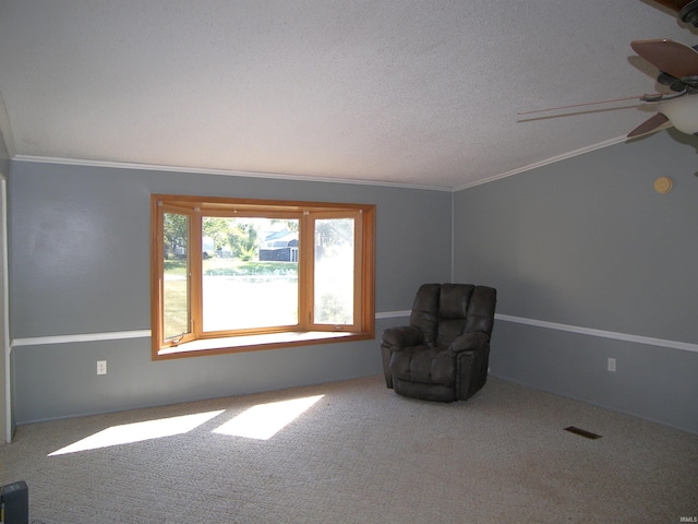 unfurnished room with a textured ceiling, carpet, ornamental molding, and ceiling fan