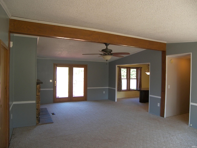 carpeted spare room with ceiling fan, plenty of natural light, and a textured ceiling