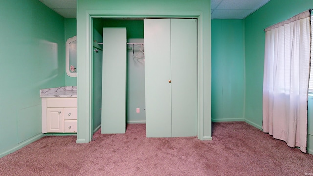 unfurnished bedroom featuring light colored carpet, sink, and a paneled ceiling