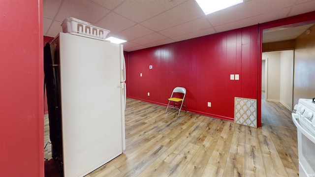 interior space with a paneled ceiling, light hardwood / wood-style floors, and white refrigerator