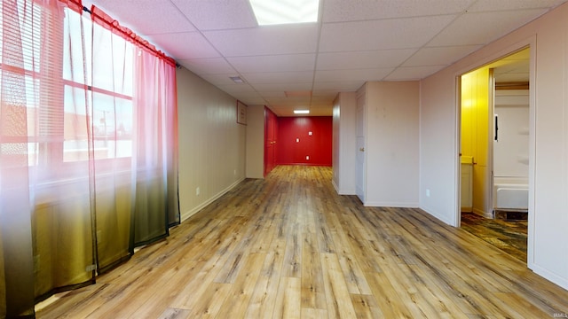 unfurnished room featuring light wood-type flooring and a paneled ceiling