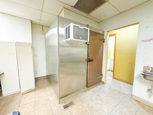 bathroom with a drop ceiling, tile patterned flooring, and a wall mounted AC