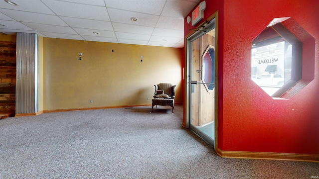 interior space with a paneled ceiling and carpet flooring