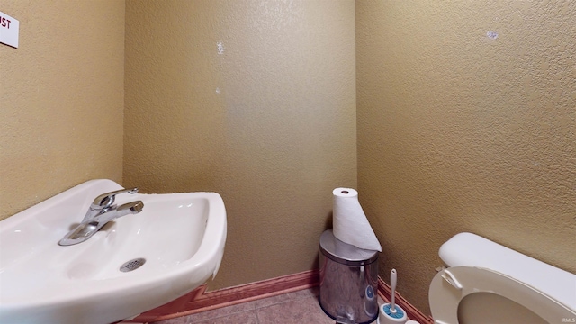 bathroom featuring tile patterned flooring, toilet, and sink