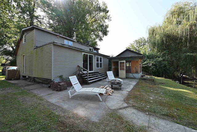 rear view of property with a patio, a yard, and an outdoor fire pit