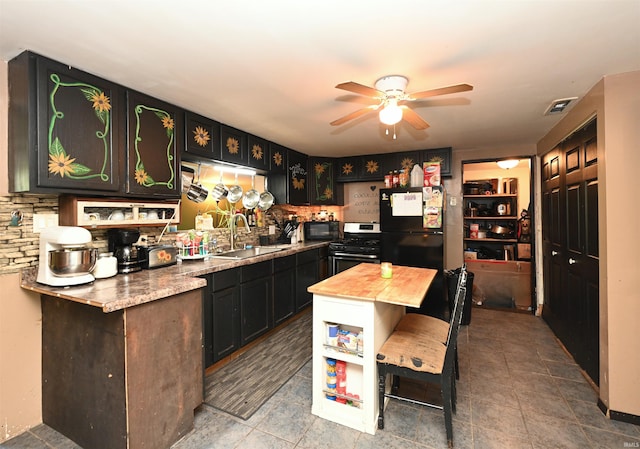 interior space featuring backsplash, a breakfast bar area, black appliances, ceiling fan, and sink