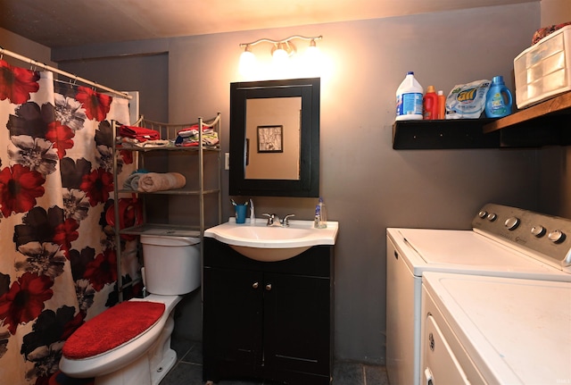 bathroom with tile patterned flooring, toilet, vanity, and washing machine and dryer