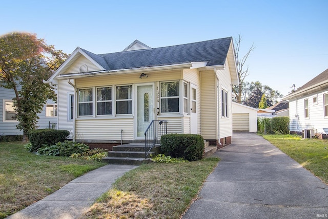 bungalow-style house with cooling unit and a front lawn