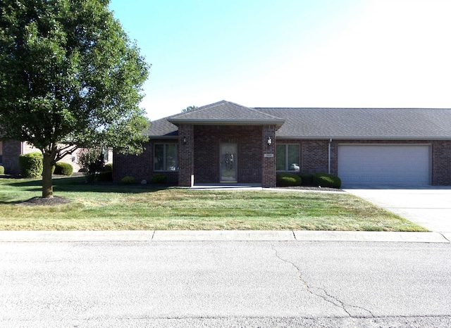 ranch-style home with a garage and a front lawn