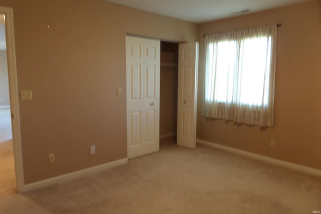 unfurnished bedroom featuring carpet floors and a closet