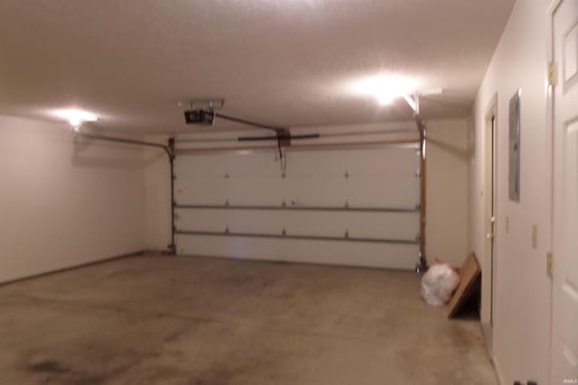 garage featuring electric panel and a garage door opener