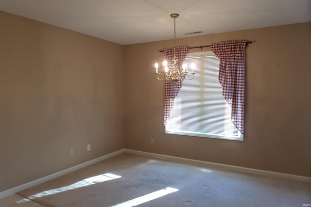 spare room with a notable chandelier and carpet flooring