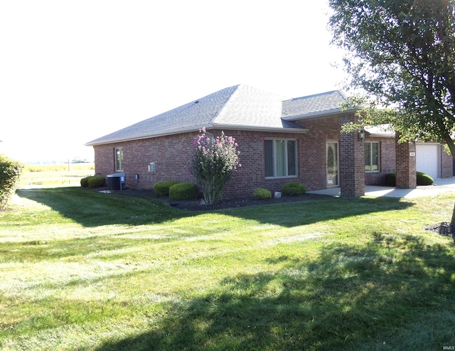 view of side of property featuring a lawn and cooling unit