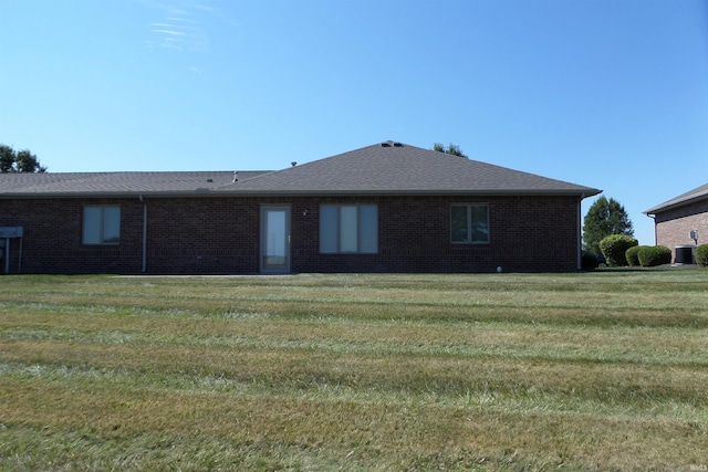 back of property featuring a lawn