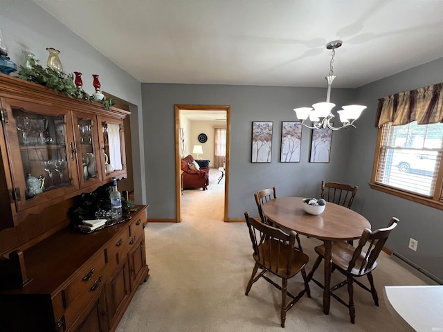 dining space featuring a chandelier and light carpet