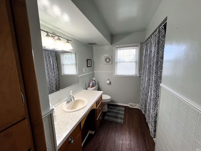 bathroom featuring vanity, tile walls, hardwood / wood-style floors, and plenty of natural light