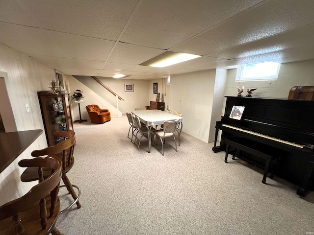 carpeted dining room with a drop ceiling