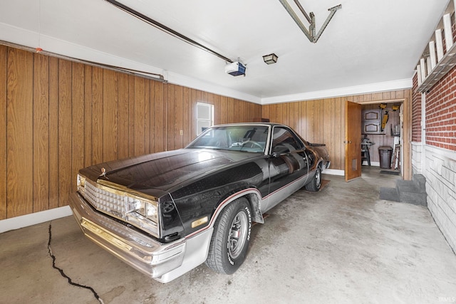 garage featuring a garage door opener and wooden walls