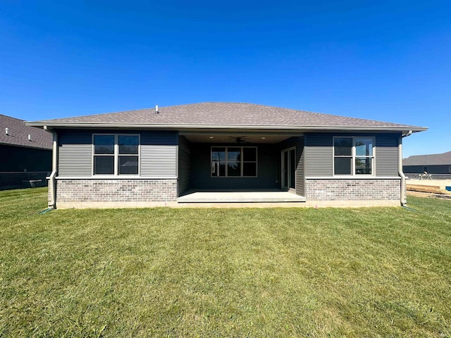 back of house with a lawn and a patio area