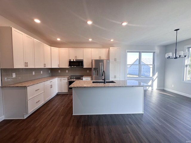 kitchen with white cabinets, sink, a center island with sink, dark wood-type flooring, and appliances with stainless steel finishes