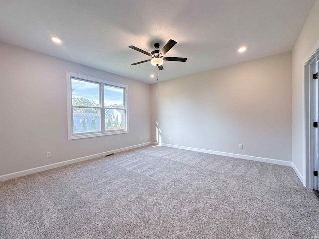 carpeted spare room with ceiling fan