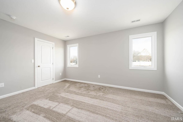 carpeted spare room featuring plenty of natural light