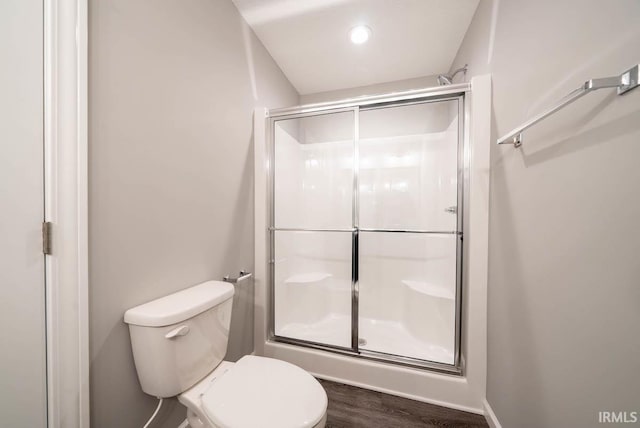 bathroom featuring wood-type flooring, toilet, and an enclosed shower