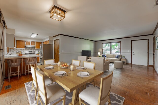 dining area with ornamental molding and dark hardwood / wood-style floors