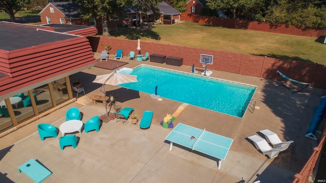 view of pool with a patio and a lawn