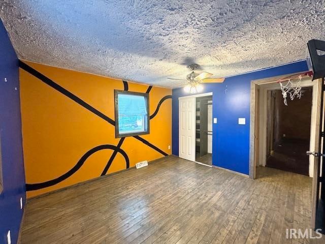 interior space with ceiling fan, hardwood / wood-style floors, and a textured ceiling