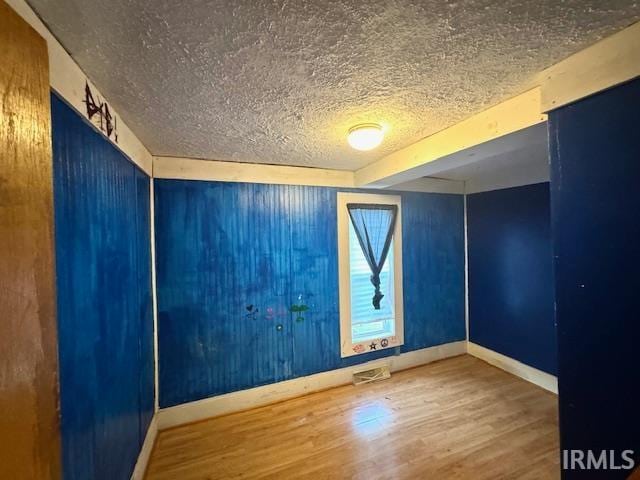 empty room featuring a textured ceiling and hardwood / wood-style flooring