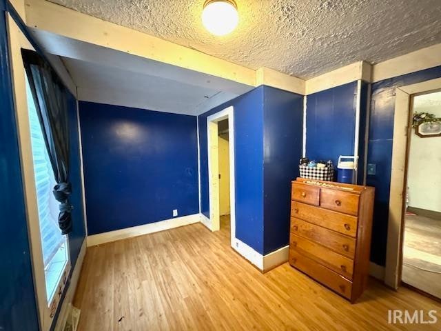 unfurnished bedroom with a textured ceiling and hardwood / wood-style floors