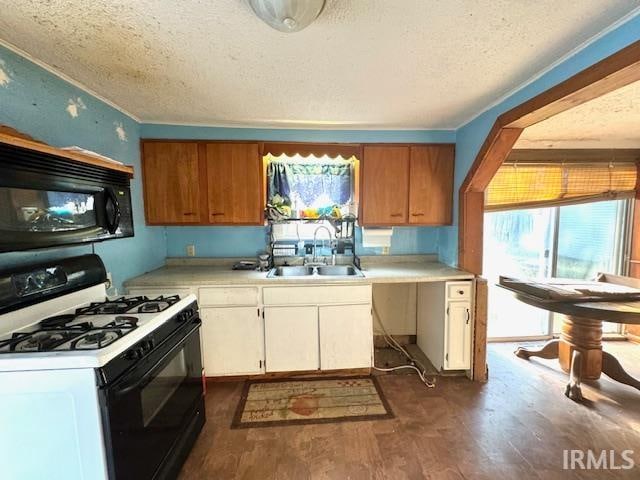 kitchen featuring white cabinets, sink, a textured ceiling, dark wood-type flooring, and white gas stove