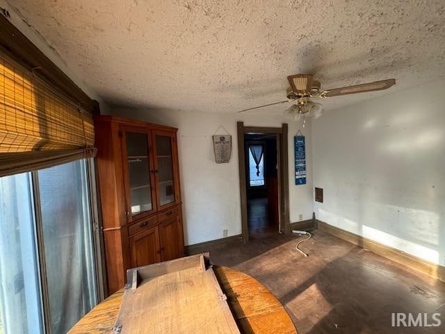 interior space featuring ceiling fan and a textured ceiling