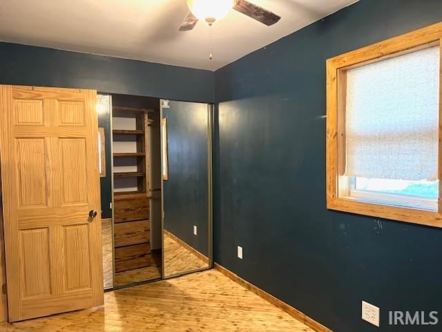 bedroom with wood-type flooring, ceiling fan, and a closet