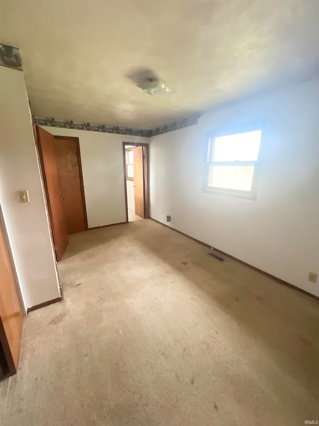 unfurnished bedroom featuring light carpet