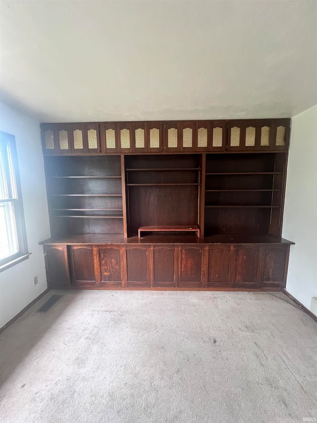 unfurnished living room featuring light carpet