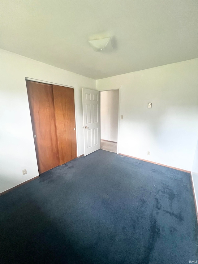 unfurnished bedroom featuring a closet and carpet flooring