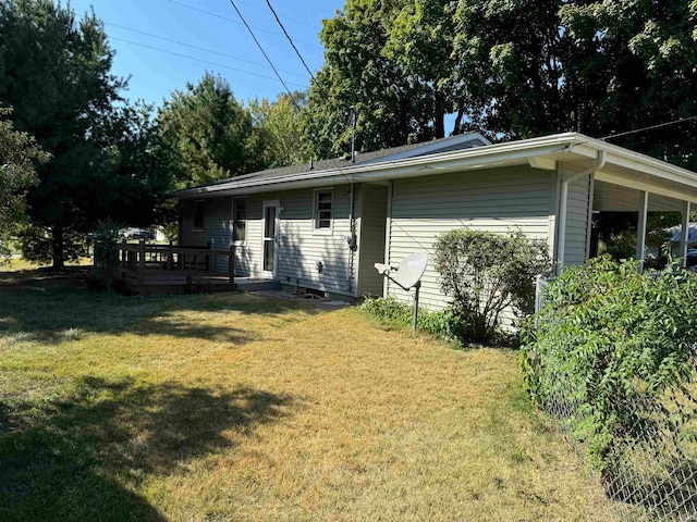 back of house featuring a deck and a yard