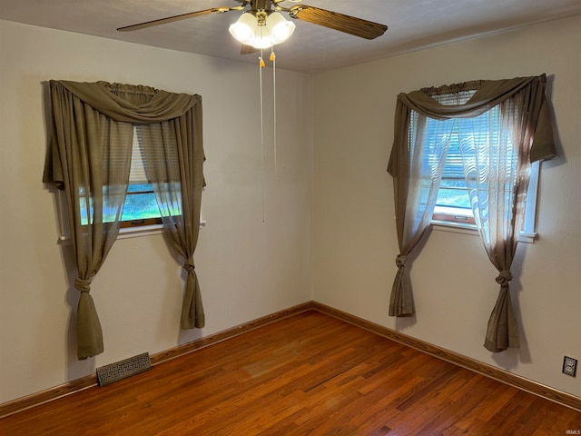 empty room with ceiling fan and hardwood / wood-style floors