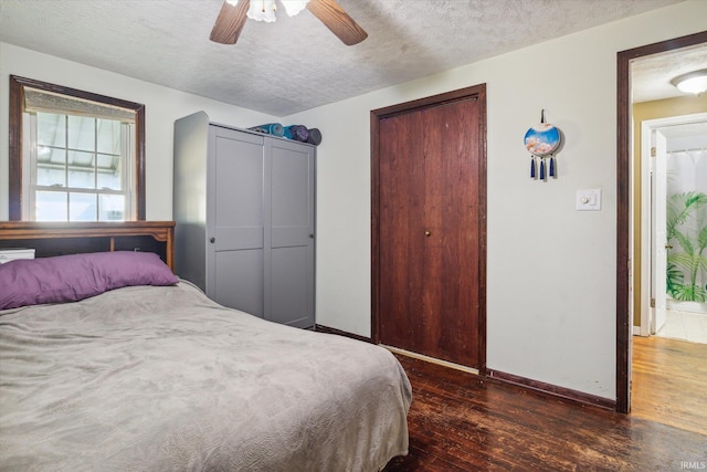 bedroom featuring ceiling fan, dark hardwood / wood-style floors, and a textured ceiling