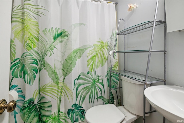 bathroom with a shower with shower curtain, sink, and toilet